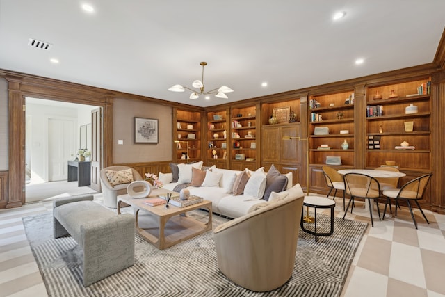 living room featuring wood walls, built in shelves, and a notable chandelier