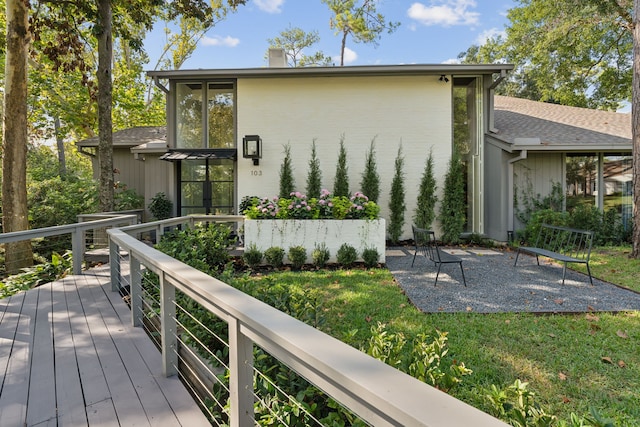 back of property featuring a yard and a deck