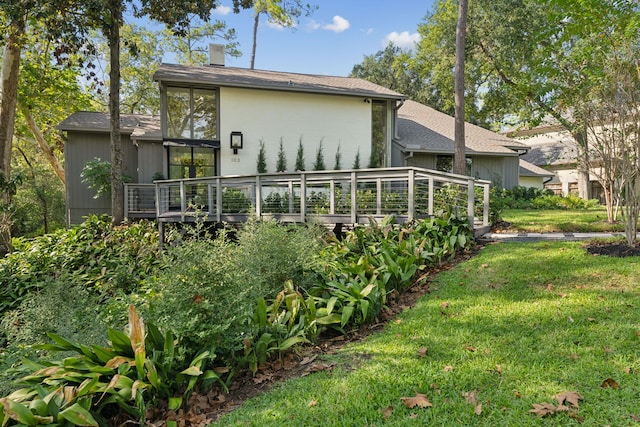 rear view of house with a deck and a yard