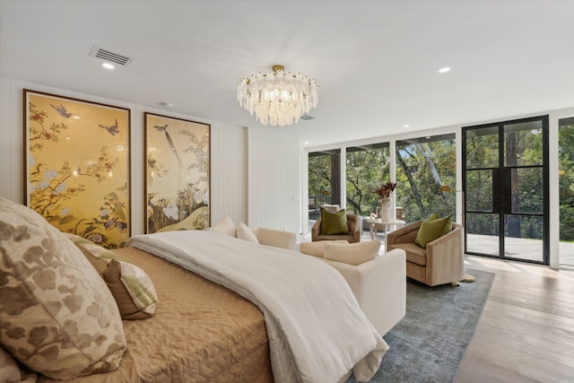 bedroom featuring floor to ceiling windows, multiple windows, a notable chandelier, and access to outside