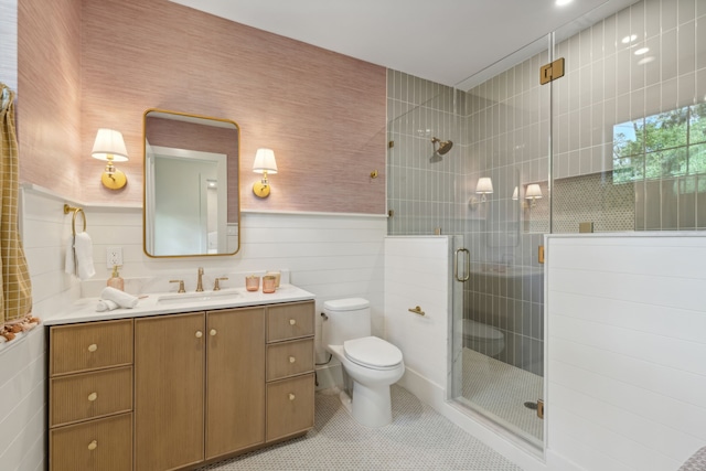 bathroom featuring vanity, toilet, tile patterned floors, and a shower with shower door