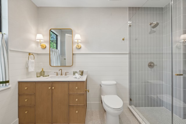 bathroom with tile patterned flooring, a shower with shower door, vanity, and toilet