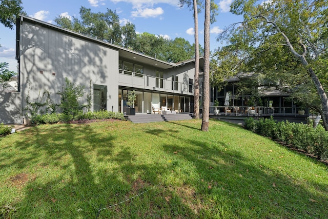 rear view of house featuring a lawn