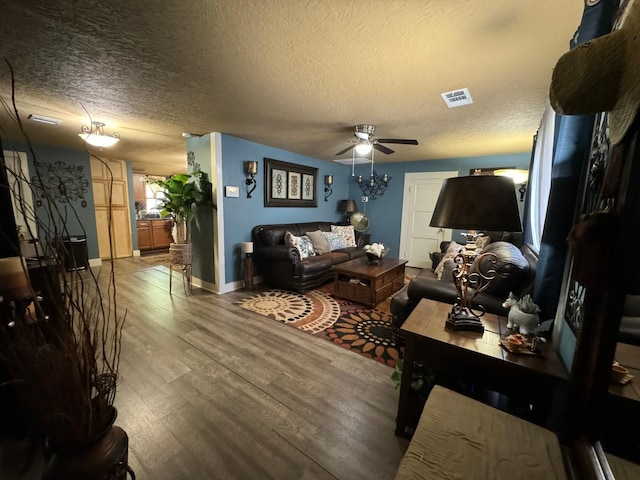 living room with a textured ceiling, ceiling fan, and hardwood / wood-style flooring