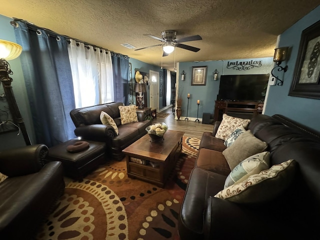 living room featuring a textured ceiling and ceiling fan