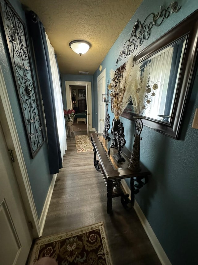 hall featuring a textured ceiling and hardwood / wood-style flooring