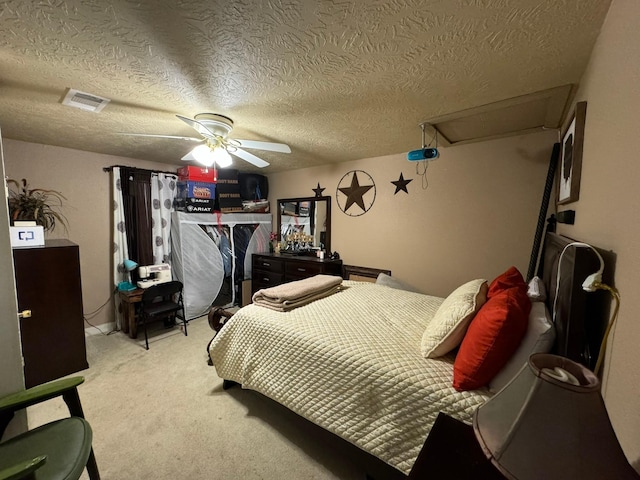 bedroom featuring a textured ceiling, ceiling fan, and light colored carpet