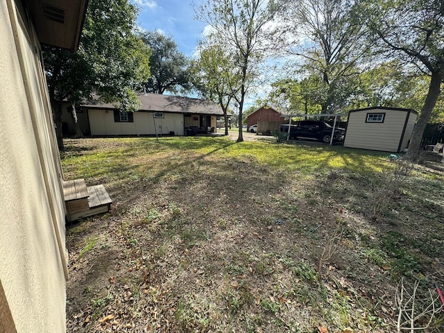 view of yard with a carport and a storage unit