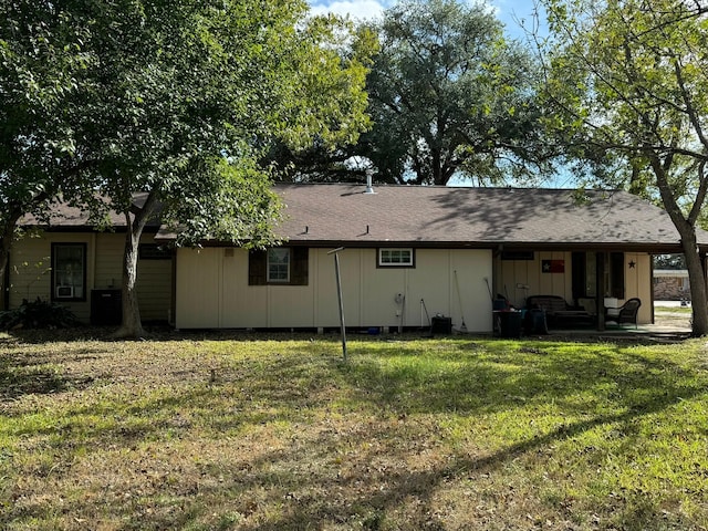 rear view of property featuring a lawn and central AC