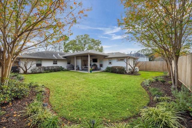 back of property with a lawn and a patio