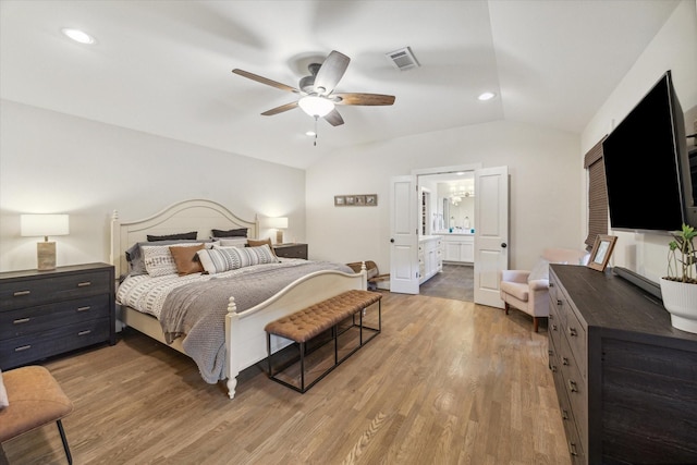 bedroom featuring ensuite bath, ceiling fan, vaulted ceiling, and wood-type flooring