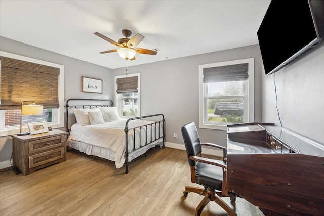 bedroom with multiple windows, ceiling fan, and light hardwood / wood-style flooring