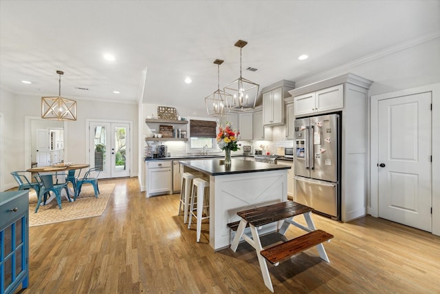 kitchen featuring decorative light fixtures, french doors, a kitchen bar, ornamental molding, and high end refrigerator