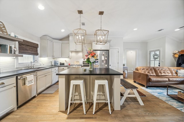 kitchen with stainless steel appliances, white cabinets, and a kitchen breakfast bar