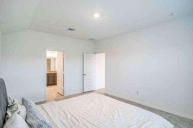 bedroom with lofted ceiling and connected bathroom