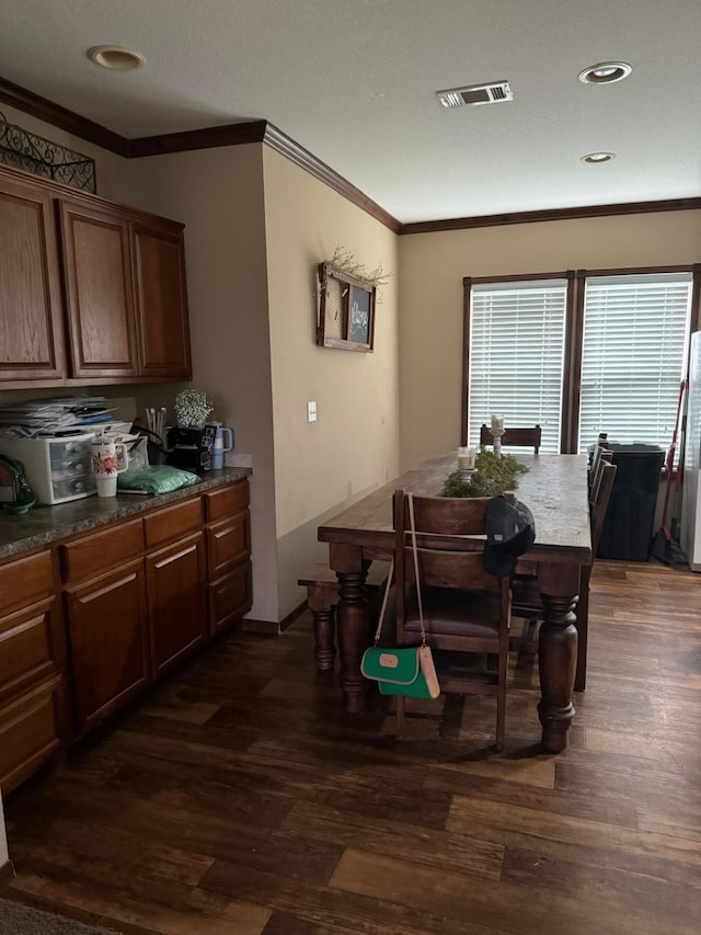 dining room featuring dark wood-type flooring and ornamental molding