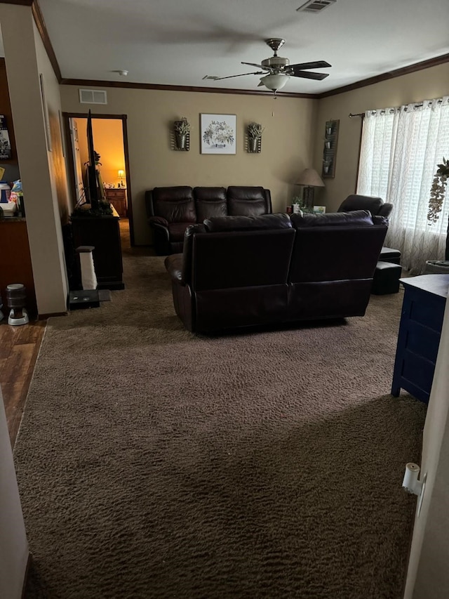 living room featuring dark carpet, ceiling fan, and ornamental molding