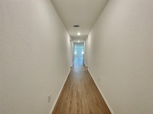 hallway with light hardwood / wood-style floors