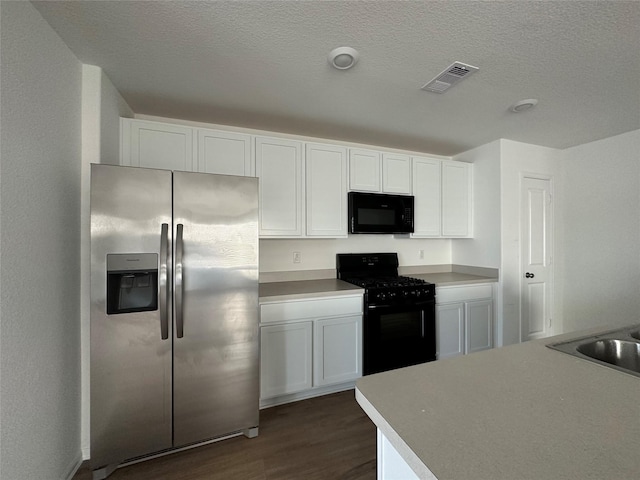 kitchen featuring a textured ceiling, black appliances, dark hardwood / wood-style flooring, white cabinetry, and sink