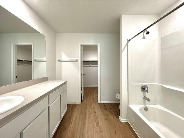 full bathroom featuring toilet, vanity, hardwood / wood-style floors, and bathing tub / shower combination