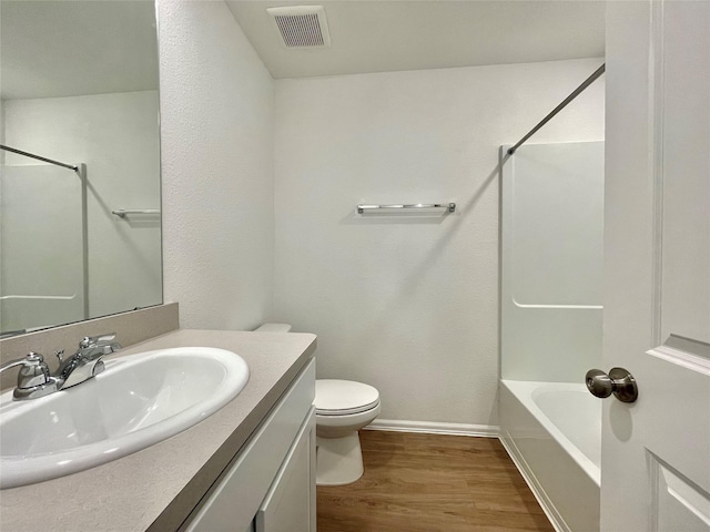 full bathroom featuring toilet, vanity, hardwood / wood-style floors, and shower / bathing tub combination