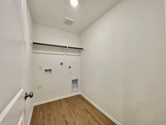 washroom with hardwood / wood-style flooring, hookup for a washing machine, hookup for an electric dryer, and gas dryer hookup