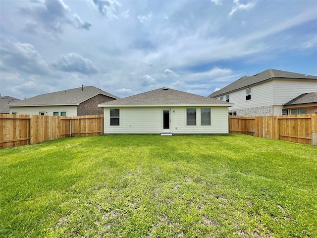 rear view of house featuring a yard