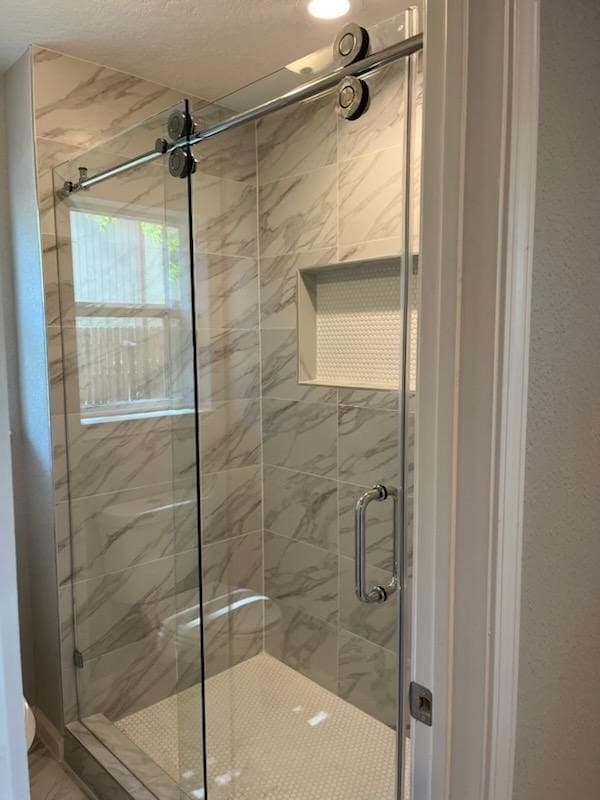 bathroom featuring a shower with shower door