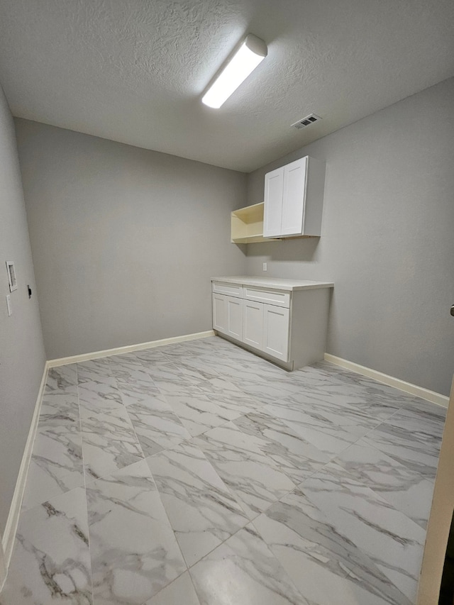 clothes washing area with a textured ceiling