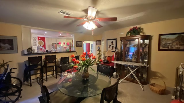 carpeted dining area featuring ceiling fan