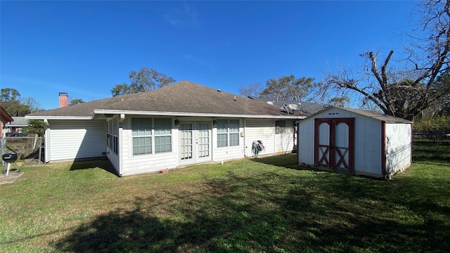 rear view of property with a lawn and a shed