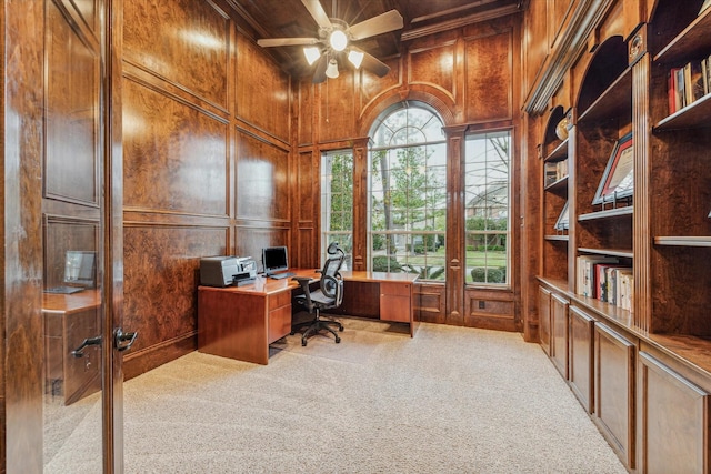 carpeted office featuring a towering ceiling and ceiling fan