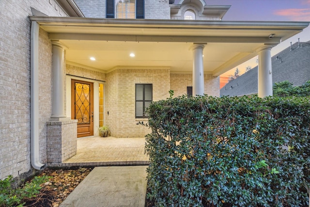 exterior entry at dusk with covered porch