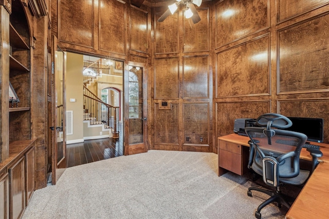 carpeted office space with ceiling fan