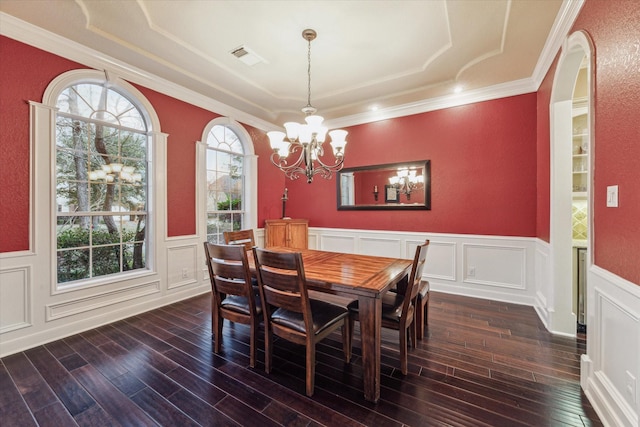 dining space with ornamental molding, a notable chandelier, and dark hardwood / wood-style flooring