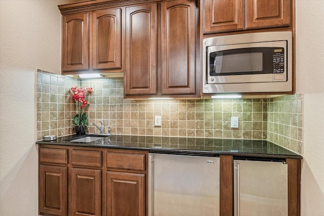 kitchen with stainless steel appliances, sink, dark stone countertops, decorative backsplash, and wine cooler