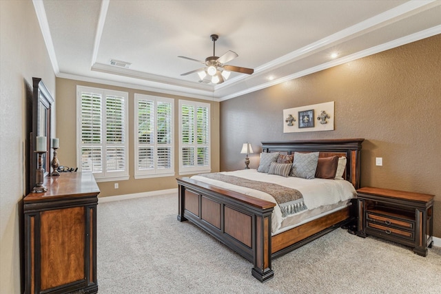 carpeted bedroom with ornamental molding, ceiling fan, and a tray ceiling