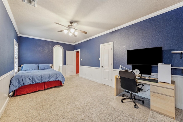 bedroom featuring light carpet, ceiling fan, a textured ceiling, and crown molding