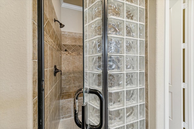 bathroom with a shower with door and ornamental molding