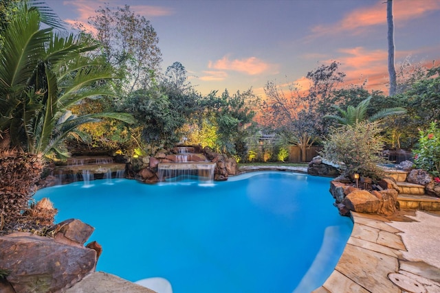 pool at dusk with pool water feature