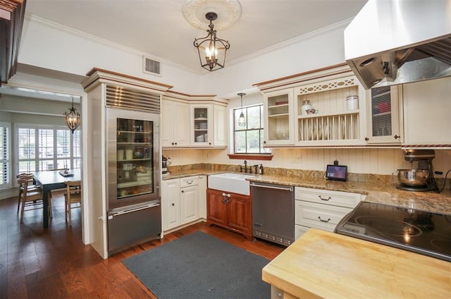 kitchen featuring island range hood, wine cooler, sink, decorative light fixtures, and stainless steel dishwasher