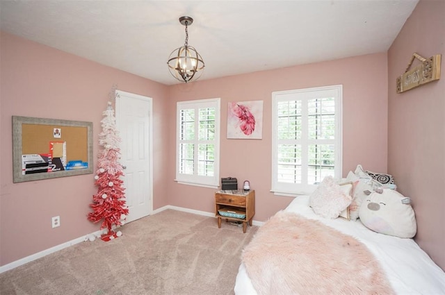 carpeted bedroom with an inviting chandelier