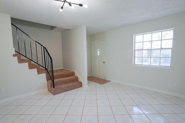 tiled entrance foyer featuring a textured ceiling