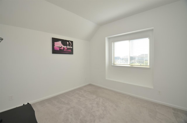 bonus room featuring lofted ceiling and light carpet