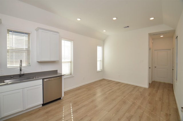 kitchen featuring white cabinets, vaulted ceiling, a wealth of natural light, sink, and stainless steel dishwasher