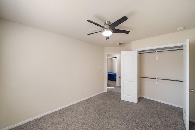 unfurnished bedroom featuring ceiling fan, a closet, and dark colored carpet