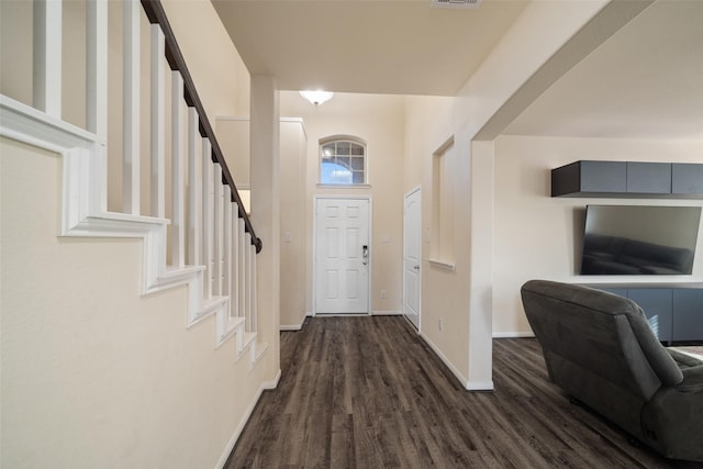 foyer featuring dark wood-type flooring and a towering ceiling