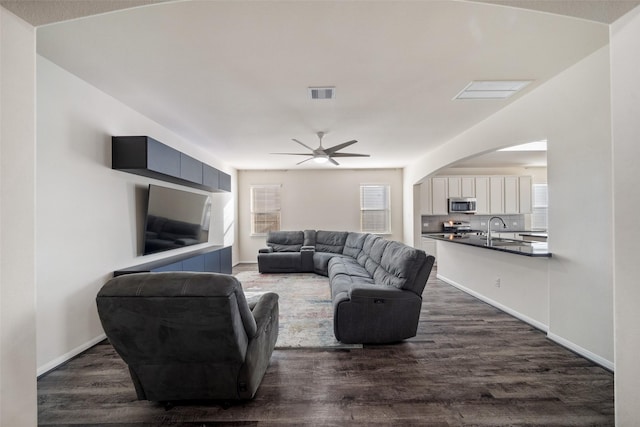 living room featuring sink, plenty of natural light, dark hardwood / wood-style floors, and ceiling fan