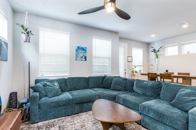 living room featuring ceiling fan and a wealth of natural light