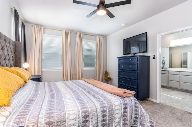 carpeted bedroom with ensuite bath and ceiling fan